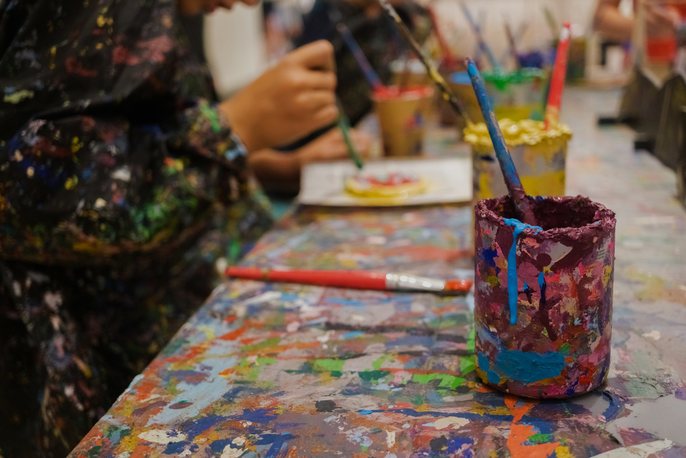 Children Enjoy Painting in Art Class, with  Hands and Smocks Full of Paint.